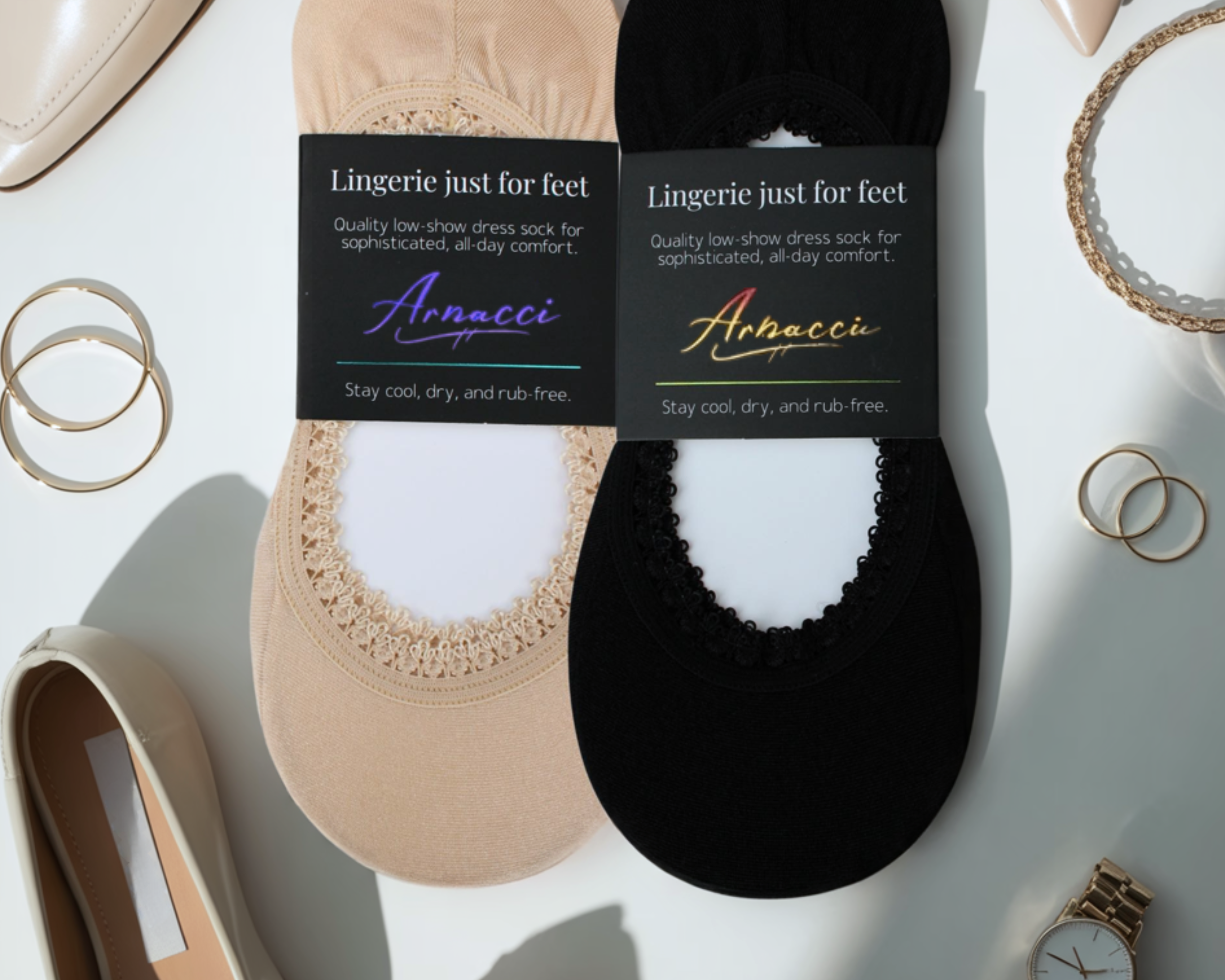Two pairs of Arnacci socks, one beige and one black, on a light background with jewelry.