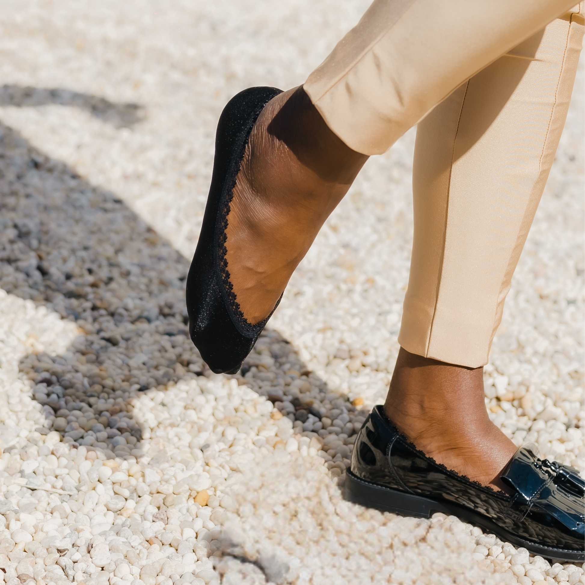 African American woman wearing black no-show footies with shimmer finish - Arbella Style luxe socks in sunlight