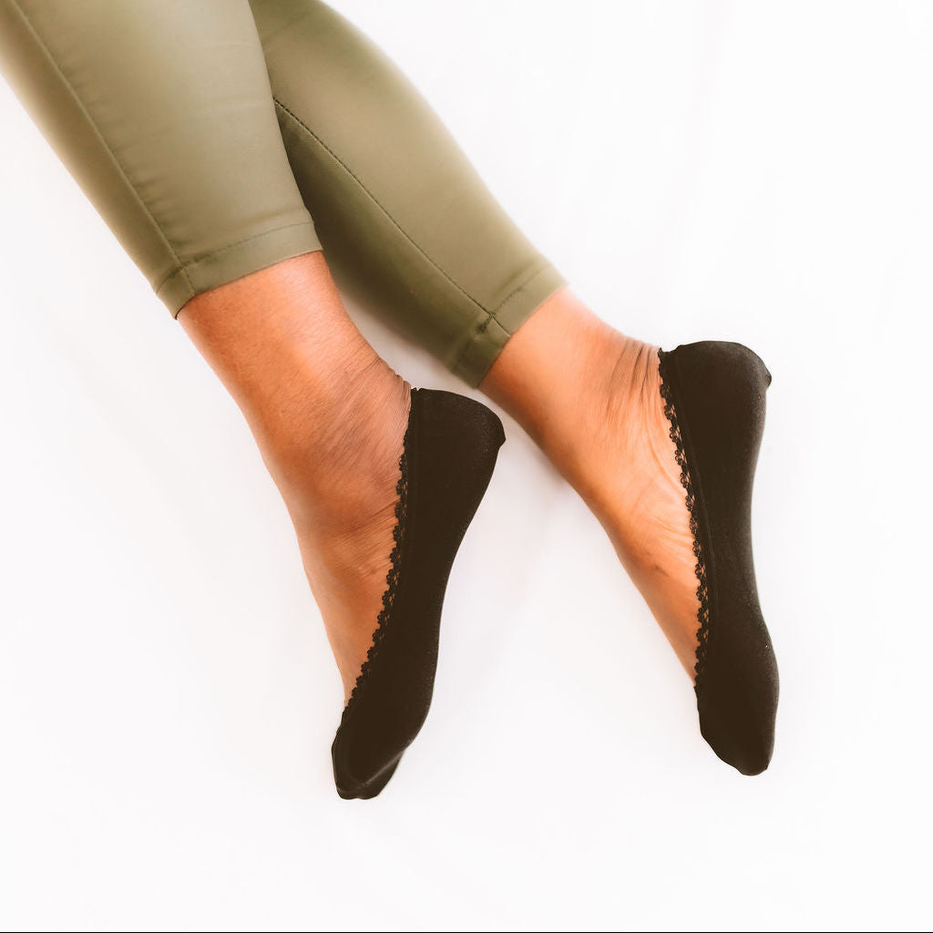 Black woman modeling black no-show footies - Arbella Style invisible socks on feet
