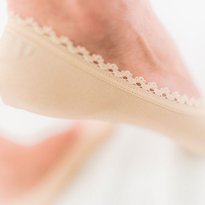 Close-up of lace detail on foot wearing Arbella Style nude footie - elegant no-show sock design