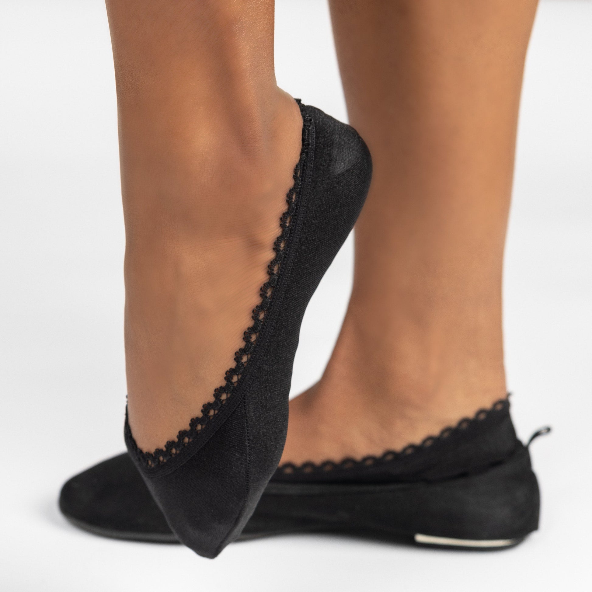 Side view of black woman wearing black ballerina flats with Arbella Style footie - elegant no-show sock